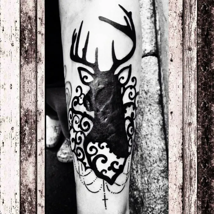 Tattoo art of a deer silhouette creatively incorporates a scar into the design.