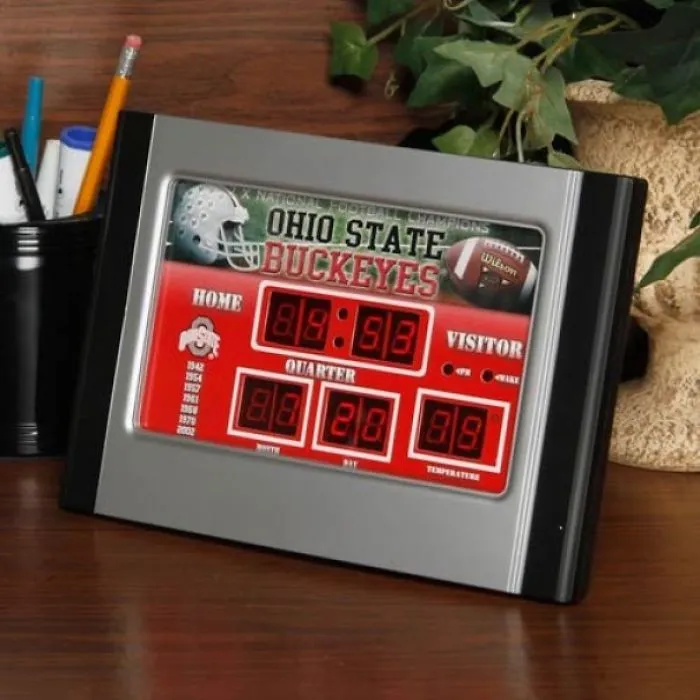 Ohio State Buckeyes clock design fail shows nonsensical scores and times on a desk with office supplies and a plant.