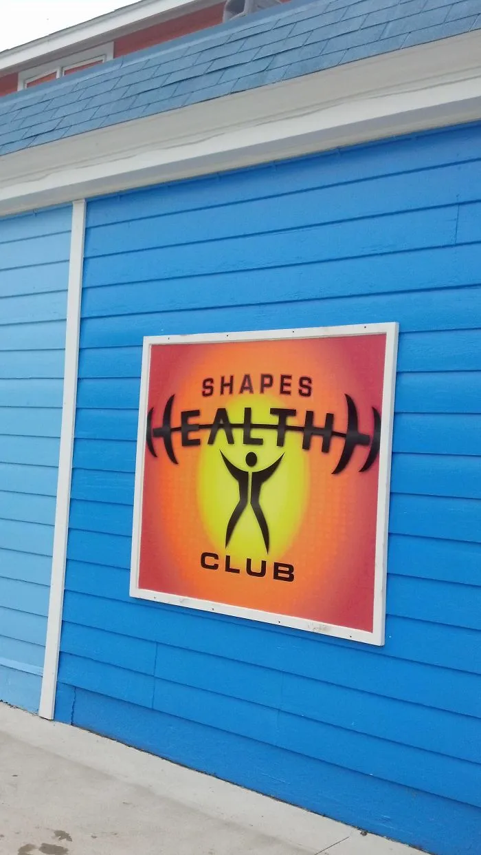 Sign on a blue wall reads "Shapes Health Club" with a humorous design fail.