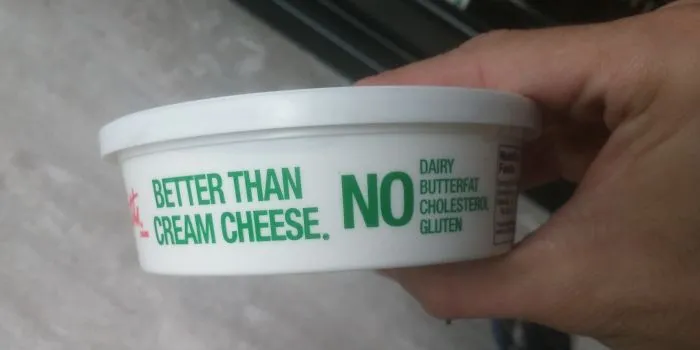 Cream cheese container with humorous design fail text: "Better Than Cream Cheese. No Dairy Butterfat Cholesterol Gluten."