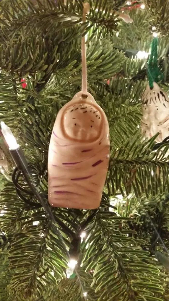 Funny design fail: strange baby ornament hanging on a Christmas tree.
