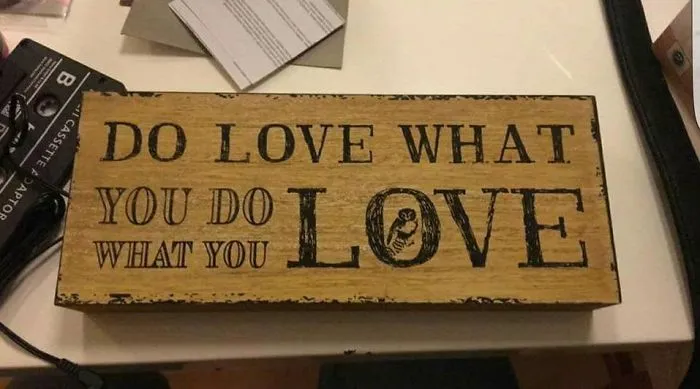 Wooden sign design fail with repeated phrase "Do what you love, love what you do" causing confusion.