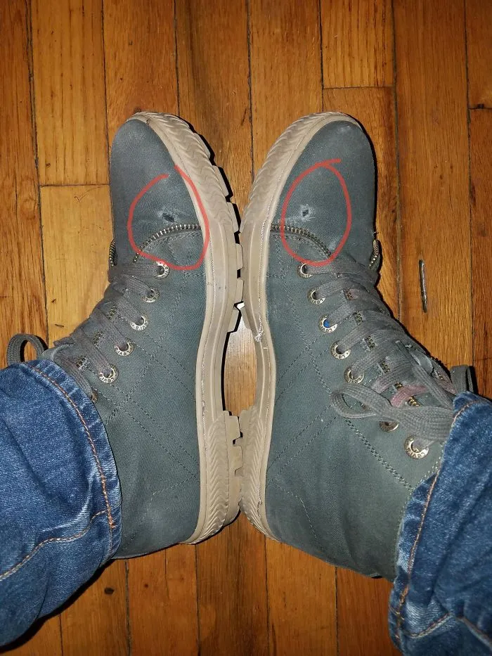 Pair of hiking boots with mismatched eyelets, demonstrating a funny design fail.
