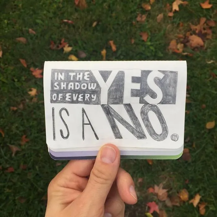 A humorous design fail with text: "In the shadow of every yes is a no," held by a hand against grassy background.