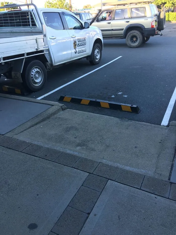 Parking lot design fail with blocked space, featuring a truck and an SUV nearby.