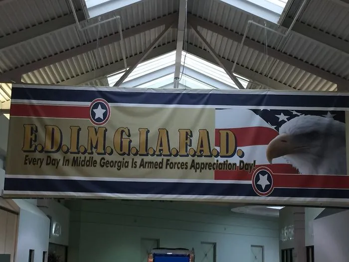Funny design fail: a banner with a lengthy acronym for Armed Forces Appreciation Day and an eagle in the background.