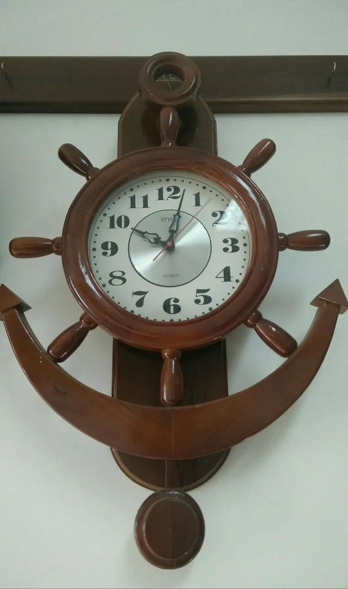 Wooden ship wheel clock with mismatched numbers, showcasing a funny design fail.
