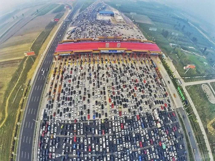 Aerial view of a massive traffic jam at a toll plaza, highlighting a funny design fail with overwhelming congestion.