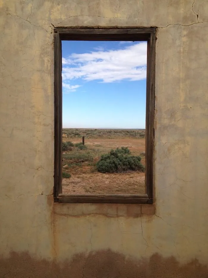 Ventana de una casa en ruinas, parece un cuadro enmarcado en la pared