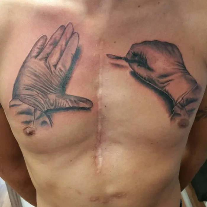 Chest tattoo art transforming scar into creative design with gloves.