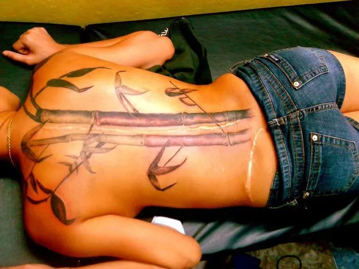 Tattoo on back turns scar into bamboo artwork.
