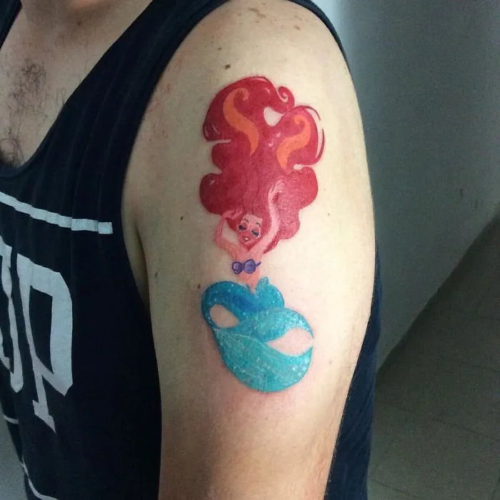 Colorful mermaid tattoo on a person's arm creatively transforming a scar into art.