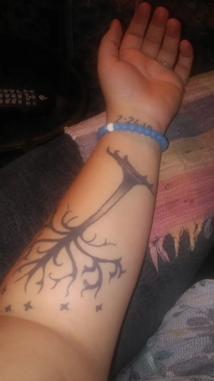 Tattoo art on forearm creatively transforms a scar, enhancing the skin with unique design elements.