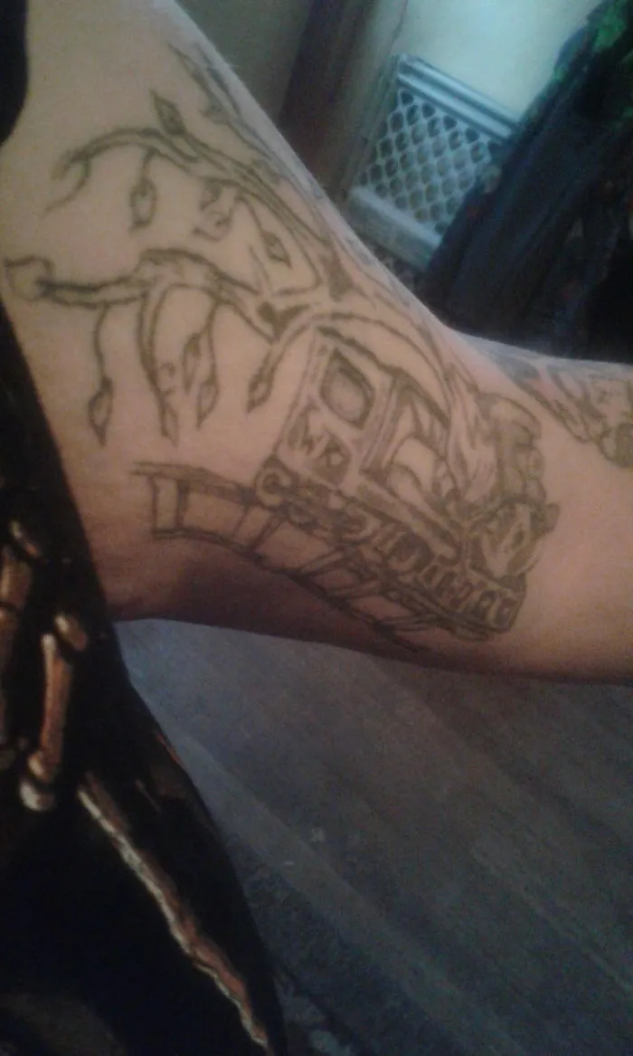 Tattoo design on arm, integrating a scar into artistic body art with a nature theme and intricate details.