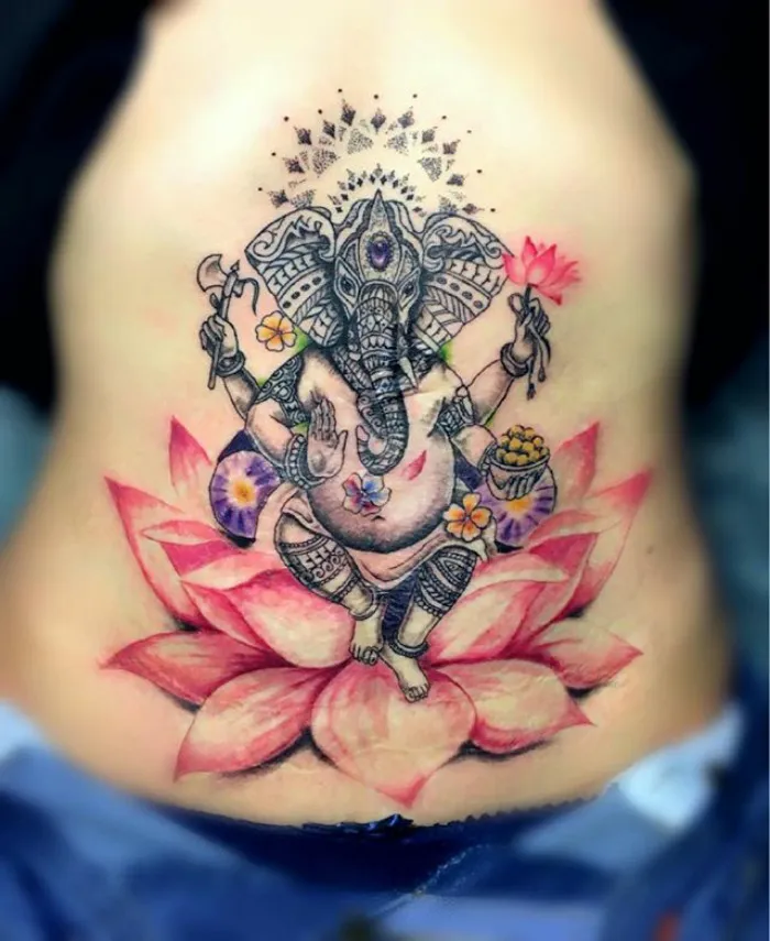 Colorful Ganesha tattoo on a lotus, transforming a scar into art.