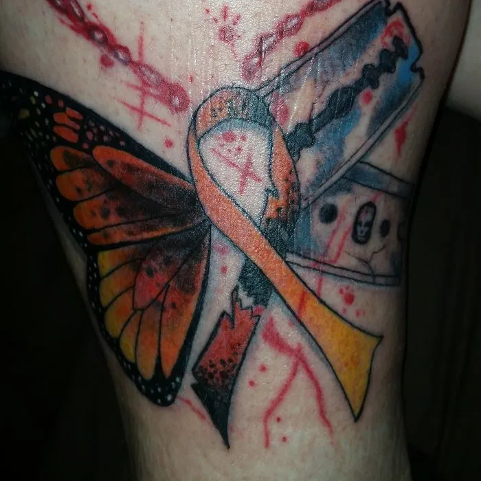 Butterfly and ribbon tattoo creatively covering a scar, transforming it into art.