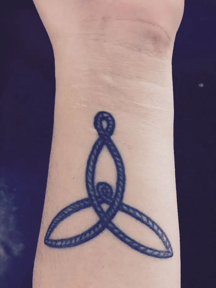 Tattoo over a forearm scar, transforming it into body art with a Celtic knot design.