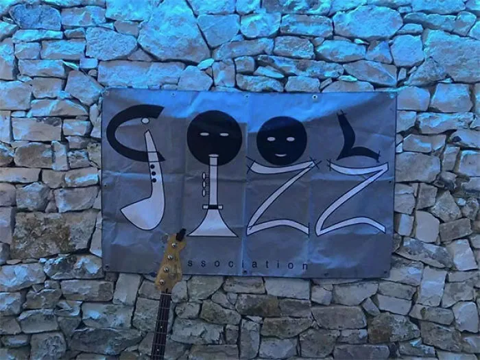 Jazz sign design fail on stone wall, with musical instruments forming letters.