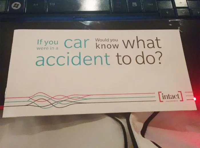 Insurance brochure design fail with confusing accident advice slogan placed on a keyboard.