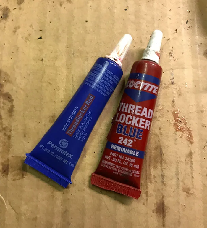 Two tubes with swapped colors: "Threadlocker Red" is blue, and "Threadlocker Blue" is red, showcasing a humorous design fail.