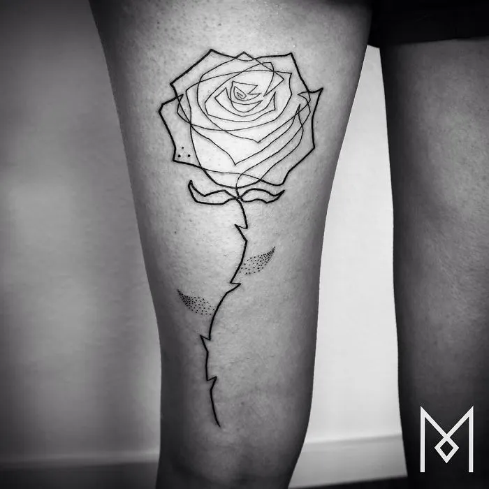 Single line rose tattoo by Mo Ganji on a person's thigh.