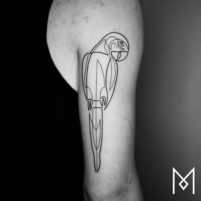 Single continuous line tattoo of a parrot on an arm, designed by Mo Ganji.