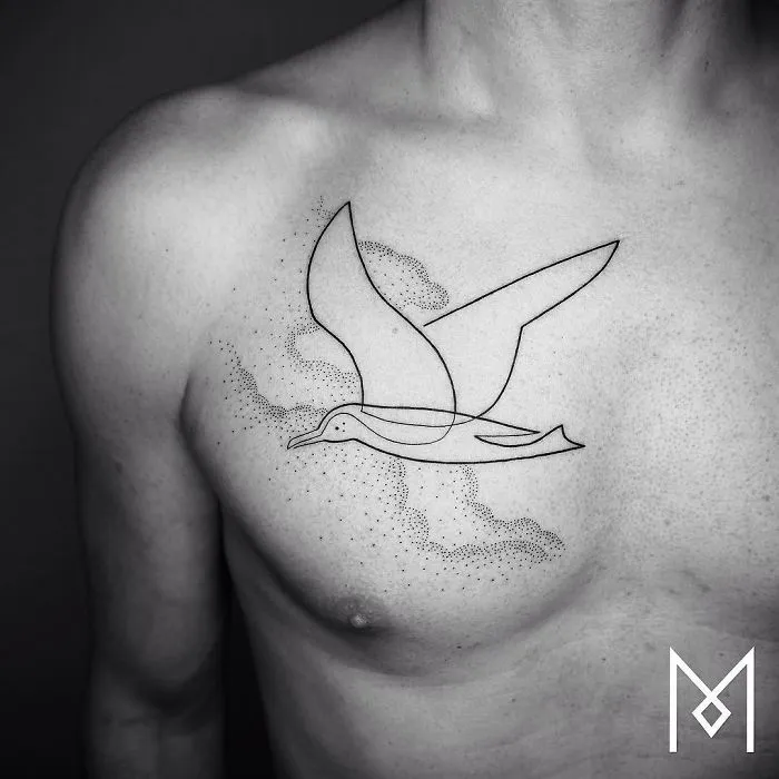Single continuous line tattoo of a bird on a person's chest by Mo Ganji.