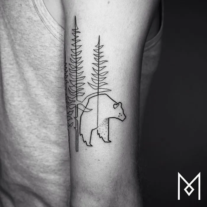 Continuous line tattoo of a bear and trees by Mo Ganji on an arm.