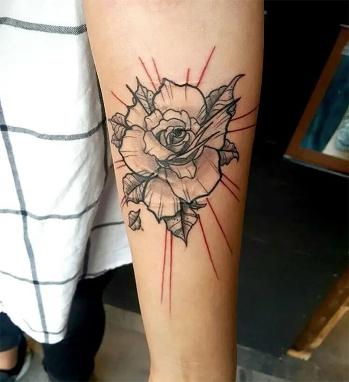 Rose tattoo art creatively covers a scar on a person's arm, showcasing transformative tattoo designs.