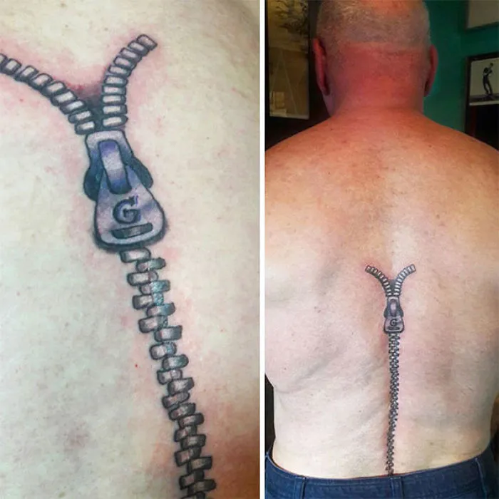 Tattoo of a zipper cleverly designed to turn a scar into an amazing work of art on a man's back.