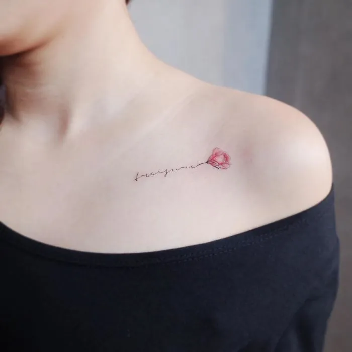 Minimalist tattoo of a delicate red flower on a person's shoulder, showing elegance and simplicity.
