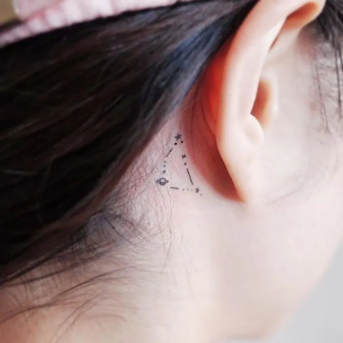 Minimalist tiny tattoo of a constellation behind the ear.