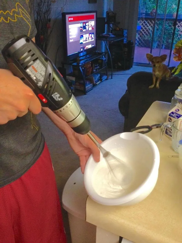 Person using a drill with a whisk attachment in a bowl, illustrating a funny aspect of married life.