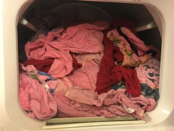Laundry mishap with pink clothes in a dryer, showcasing a humorous aspect of being married.