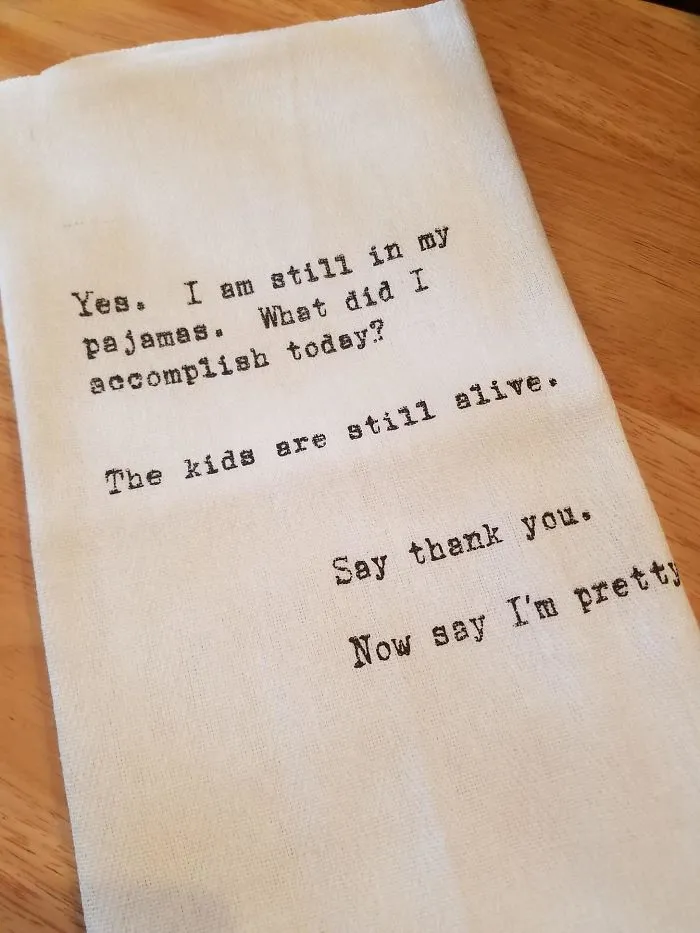 Humorous text on a towel highlights funny aspects of marriage with quotes about parenting and self-appreciation.