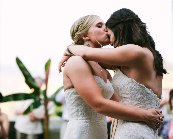One woman kissing other woman on forehead