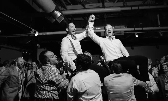 Two happy men holding hands while being in the air 