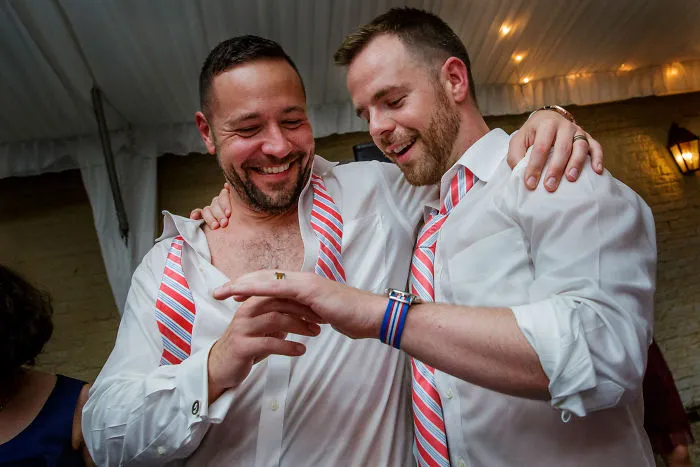 Two happy men holding hands 