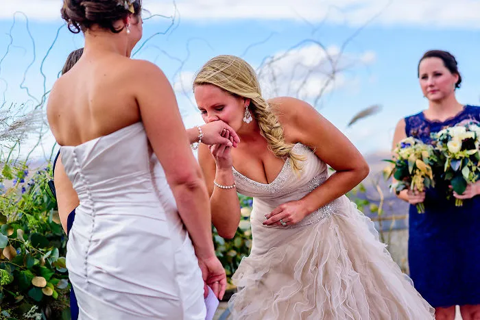 One woman kissing other woman's hand 