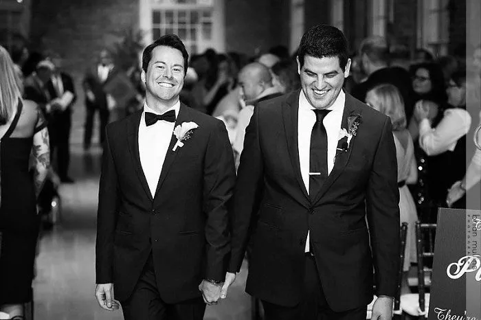 Two men holding hands 