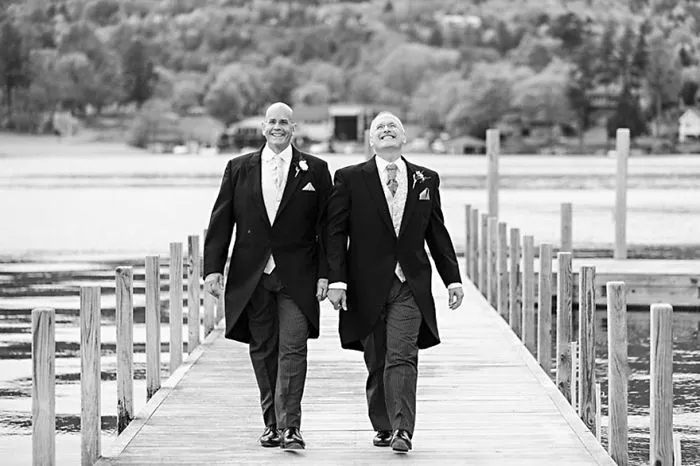 Two men holding hands and walking 