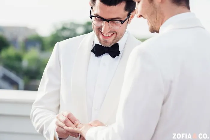One man pts a ring on other man's finger 