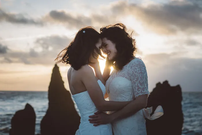 Two woman hugging in sunset on the beach 