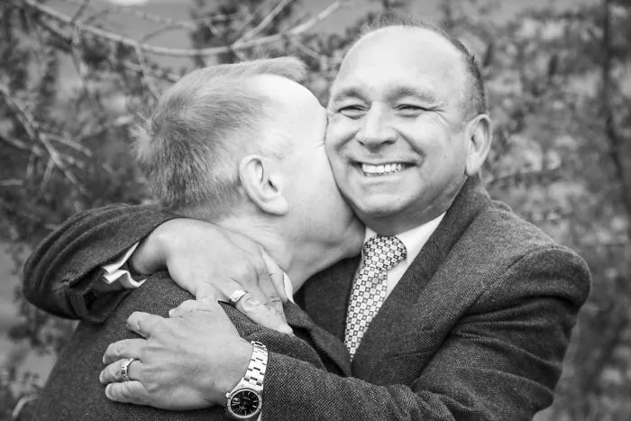 Two men kissing and hugging 