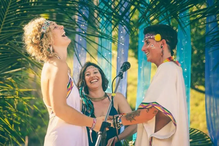 Two happy woman standing near a pastor 