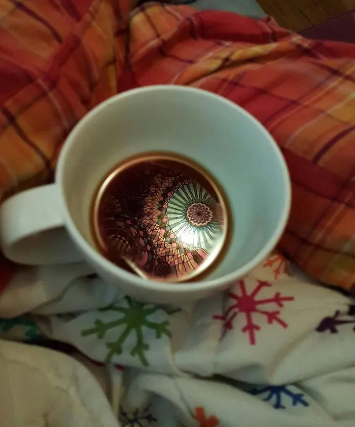 El tapiz sobre mi cama reflejándose sobre mi café