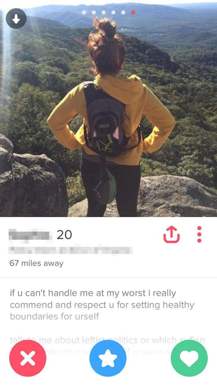 Woman in a yellow hoodie with a backpack, standing on a mountain, featured in funniest Tinder profiles.
