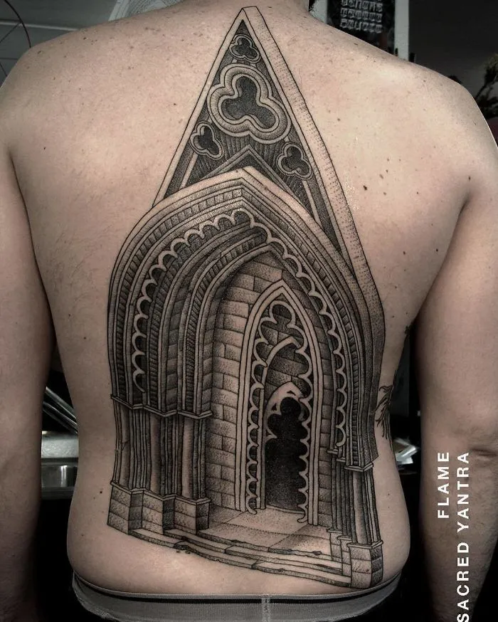 Intricate architecture tattoo of a Gothic arch design on a person's back.