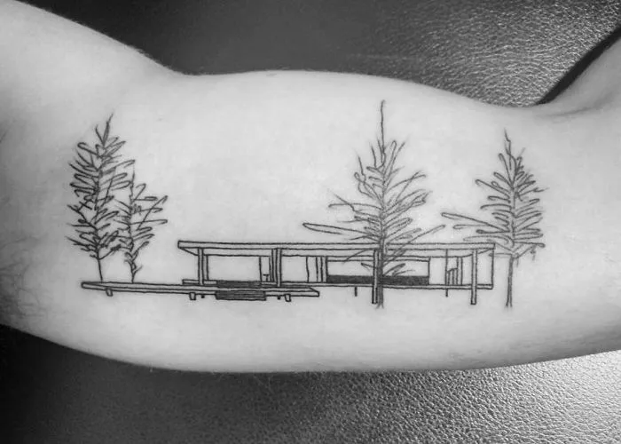 Architectural tattoo of modern building and trees on arm, showcasing intricate design.