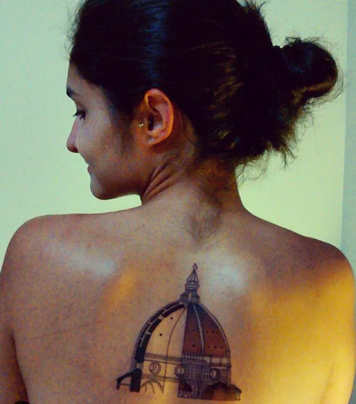 Woman with an intricate architecture tattoo of a dome on her back, showcasing unique artistic ink design.